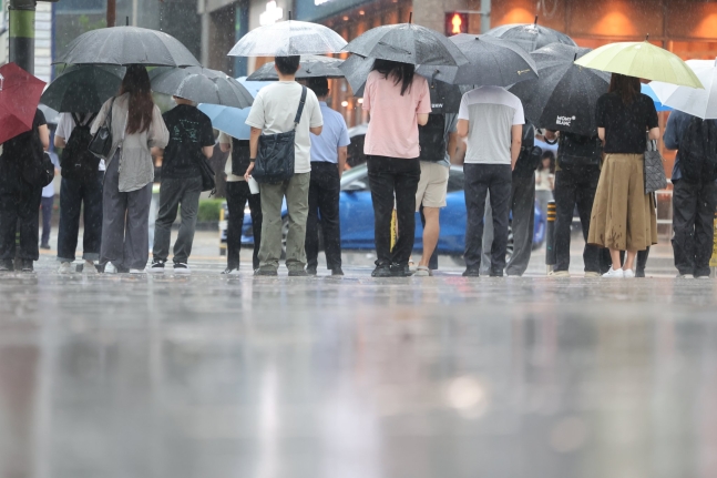 중부 지방에 호우특보가 내려진 18일 서울 강남역 인근에서 우산을 쓴 시민들이 발걸음을 재촉하고 있다. 뉴스1