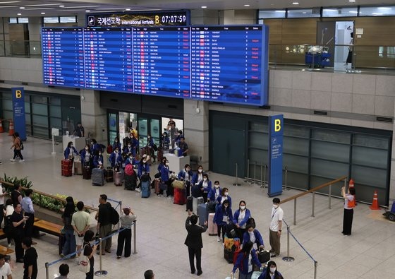 Foreign housekeepers participating in the pilot project for foreign housekeepers arriving at Incheon International Airport Terminal 1 by bus after their arrival on the morning of August 6. Yonhap News
