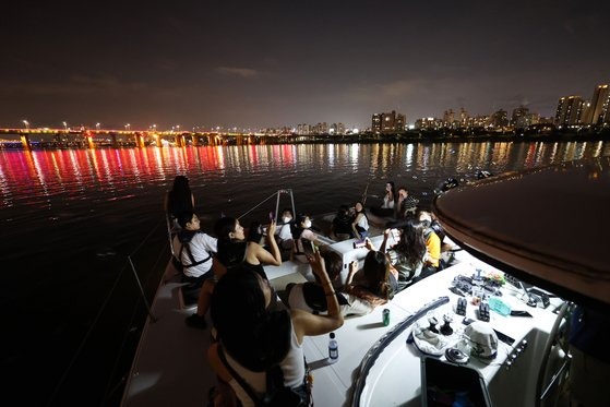 Citizens participating in the 'Rainbow Bridge Yacht Festival' held at Sebitseom in Banpo Hangang Park, Seoul in 2022 are enjoying the night view of the Han River on a yacht. Photo by Woo Sang-jo
