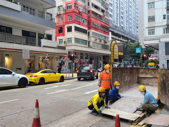 上個月27日上午6:30,三名女工(左)和一名男工人在香港旺險的一條街道上工作。香港=記者漢·吉(Han Ji -hye)