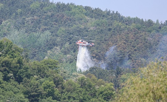 대구 북구 함지산 산불 이틀째인 29일 오후 산불 진화 작전에 투입된 산림청 산불 진화용 헬기가 함지산 상공에서 물을 뿌리고 있다. 뉴스1
