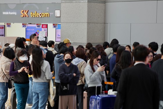 29일 오전 인천국제공항을 통해 출국하려는 여행객들이 SK텔레콤 로밍센터에서 유심 교체 서비스를 이용하기 위해 대기하고 있다. [뉴시스]