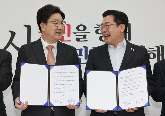 1일 서울 여의도 국회에서 더불어민주당 박찬대 당대표 직무대행 겸 원내대표(오른쪽)와 국민의힘 권성동 원내대표가 추경안 합의문에 서명한 뒤 미소짓고 있다.연합뉴스