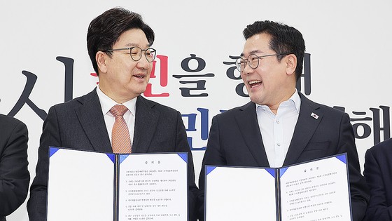  1일 서울 여의도 국회에서 더불어민주당 박찬대 당대표 직무대행 겸 원내대표(오른쪽)와 국민의힘 권성동 원내대표가 추경안 합의문에 서명한 뒤 미소 짓고 있다. 연합뉴스