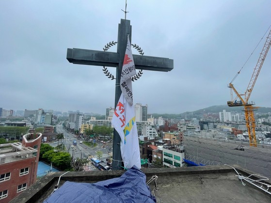 1일 서울 종로구 소재 혜화동성당의 종탑 위 십자가에 전국탈시설장애인연대 깃발이 걸려 있다. 사진 전국탈시설장애인연대