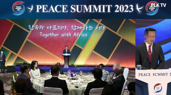 지난해 5월 서울 잠실 롯데호텔월드에서 열린 피스 서밋(PEACE SUMMIT) 2023 개회식에서 당시 통일교 세계본부장 윤모씨가 자료 사진으로 2022년 11월 아프리카 대사단 초청 만찬에서 연설하는 윤석열 전