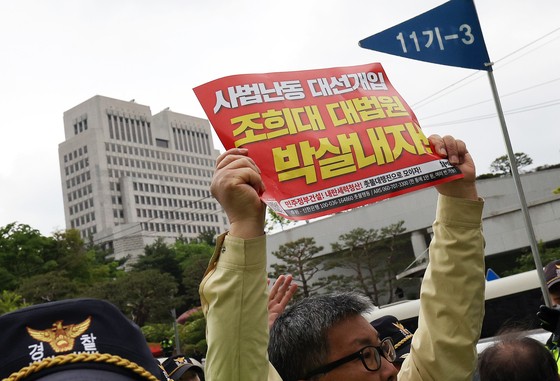 지난 3일 오후 서울 서초구 대법원 앞에서 열린 촛불행동 주최 제138차 촛불대행진에서 참가자들이 대법원 청사 건물을 향해 '조희대 대법원 박살내자'고 적힌 피켓을 들고 있다.뉴스1