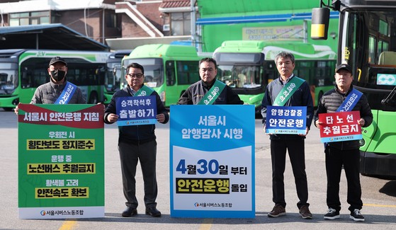 서울 시내버스 노조가 준법투쟁을 재개한 7일 오전 서울 성동구 태진운수 앞에서 노조원들이 버스교섭 타결을 촉구하며 피켓 시위를 하고 있다.준법운행은 승객이 탑승 후 자리에 앉는 등 안전이 확보된 것을 확인 후 출발