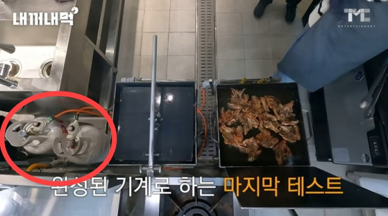 백종원 더본코리아 대표가 실내에 고압 가스통을 두고 그 옆에서 튀김 요리를 하는 장면.사진 백 대표 유튜브 영상 캡처