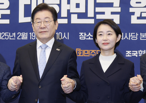 이재명 더불어민주당 대표, 김재연 진보당 상임대표가 지난 2월 19일 서울 여의도 국회에서 열린 '내란종식 민주헌정수호 새로운 대한민국 원탁회의' 출범식에서 손을 맞잡고 기념 촬영하고 있다. 뉴스1