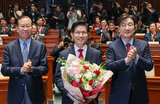 김문수 국민의힘 대통령 후보가 9일 서울 여의도 국회에서 열린 의원총회에서 꽃다발을 받은 뒤 기념 촬영하고 있다. 왼쪽부터 권영세 비대위원장, 김 후보, 권성동 원내대표. 김 후보는 지도부를 향해 "무소속을 당 후보