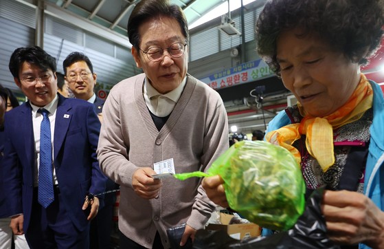 이재명 더불어민주당 대선 후보가 제3차 골목골목 경청투어로 경북지역 방문에 나선 9일 경북 영천시 영천공설시장을 찾아 한 가게에서 영천사랑상품권으로 말린 고추를 구매하고 있다. 연합뉴스