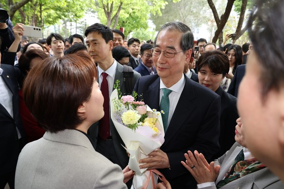 한덕수 무소속 대선 예비후보가 8일 김문수 국민의힘 대통령 후보와의 단일화 회동을 위해 서울 여의도 국회 강변서재로 향하다 꽃다발을 받고 있다. 뉴스1