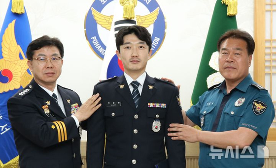지난달 산불 당시 인명 구조로 1계급 특별승진 한 백종현 경위(가운데).[사진 포항남부경찰서]