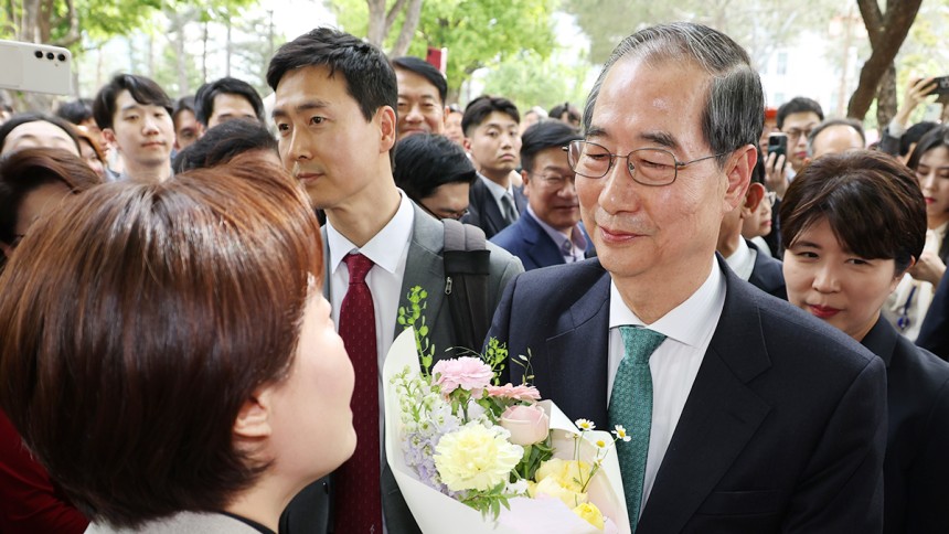 한덕수 무소속 대선 예비후보가 지난 8일 김문수 국민의힘 대통령 후보와의 단일화 회동을 위해 서울 여의도 국회 강변서재로 향하다 꽃다발을 받고 있다. 뉴스1