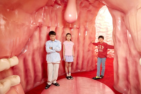 박준후 학생기자·임서희 학생모델·김산하(왼쪽부터) 학생기자가 입과 위,장을 재현해 놓은 방에 들어가 유산균이 어떤 역할을 하는지 체험했다.