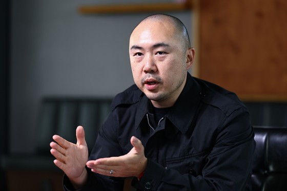 민머리에 검정 사파리와 면바지는 김정균 대표의 트레이드 마크다.첫 아이 돌 즈음 배냇머리를 민 이후로 같이 민머리를 유지하고 있다.검정 사파리와 검정 바지는 옷에 신경쓰기 싫어서라고 답했다.김종호 기자