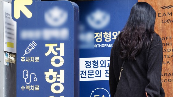 한 시민이 정형외과의원의 홍보물을 지나고 있다.뉴스1