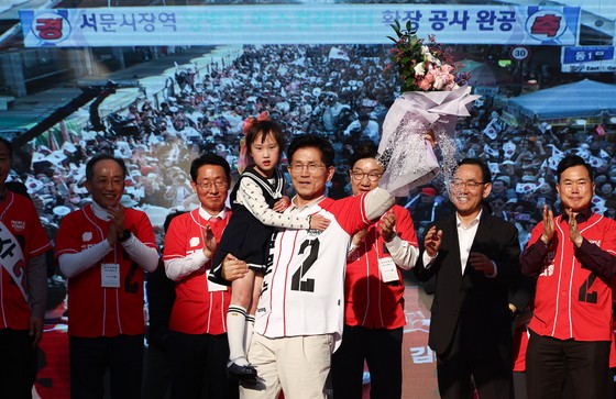 제21대 대통령 선거 공식 선거운동 첫날인 12일 김문수 국민의힘 대통령 후보가 대구 중구 서문시장에서 유세도중 어린이와 손을 들어보이고 있다. 뉴스1
