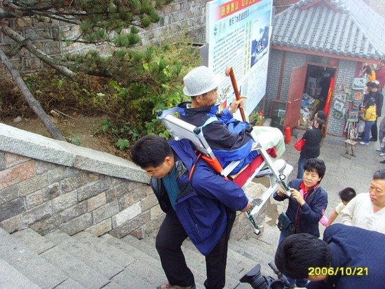 지게 효자 이군익씨가 2006년 중국 산둥성의 태산을 오르고 있다. 아버지(당시 92세)가 지팡이를 잡고 지게 의자에 앉아 있다. [이군익 제공]