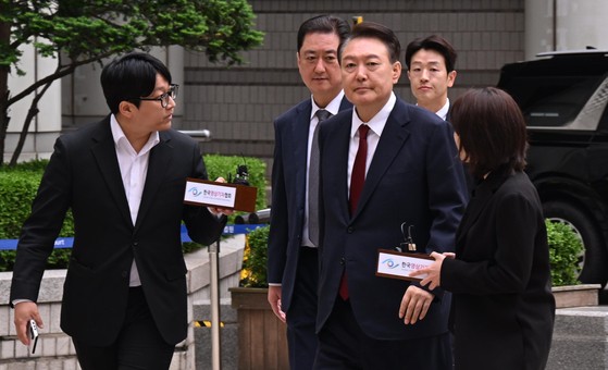윤석열 전 대통령이 19일 서울 서초구 중앙지방법원에서 열린 내란 우두머리 혐의, 직권남용 권리행사방해 혐의 사건 4차 공판에 출석, 취재진의 질문을 받으며 이동하고 있다. 연합뉴스