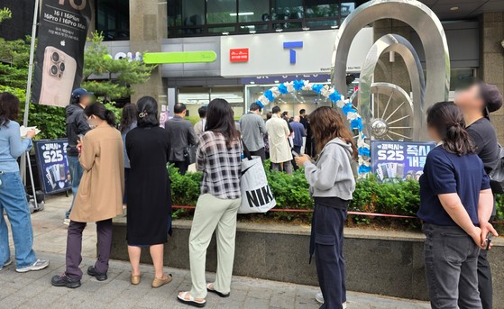 지난 20일 서울 시내 한 SK텔레콤 공식인증 대리점 앞에 고객들이 유심 교체를 위해 길게 줄을 서 기다리고 있다. 연합뉴스, 