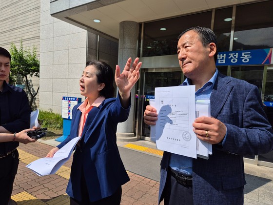 김영선 전 국회의원(왼쪽)이 26일 오전 경남 창원지법 법정동 앞에서 '홍준표 전 대구시장 측근이 미래한국연구소 쪽에 준 수표'라며 수표 2장을 공개하고 있다. 안대훈 기자