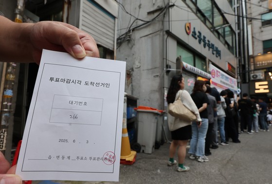 제21대 대통령선거 사전투표 둘째 날인 30일 서울 중구 소공동주민센터에 마련된 사전투표소에서 투표 종료 이후에도 투표하지 못한 한 유권자가 대기표를 들고 투표 순서를 기다리고 있다. 연합뉴스