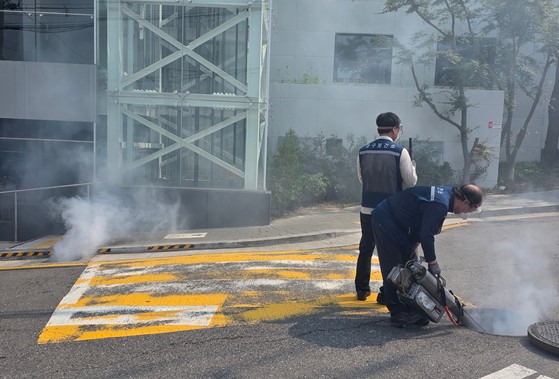 지난달 28일 오후 서울 중구 버티고개역 인근 골목에서 중구 보건소 직원들이 하수구에 휴대용 연무기를 넣고 모기 방역을 진행하고 있다. 이영근 기자