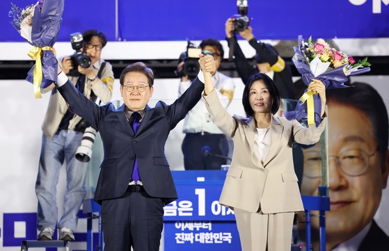 제21대 대통령 당선이 확실시되는 더불어민주당 이재명 대선 후보와 부인 김혜경 여사가 4일 서울 여의도 국회 인근에서 당 주최로 열린 국민개표방송 행사에 참석해 박찬대상임총괄선대위원장과 정은경 총괄선대위원장단으로부터