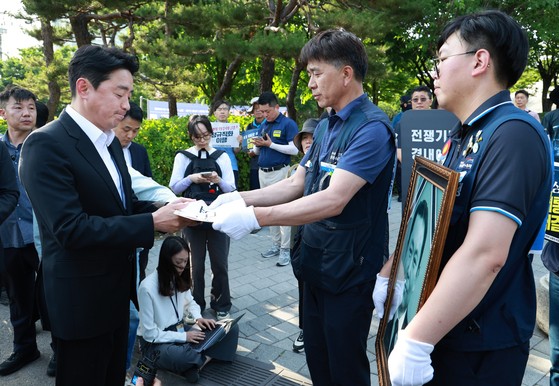 강훈식 대통령비서실장이 6일 서울 용산 대통령실 청사 인근 전쟁기념관 앞에서 태안화력발전소 사고 희생자 고(故) 김충현 씨와 관련해 엄길용 공공운수노조 위원장, 유족, 사고 대책위 관계자로부터 요구안 서한을 직접 받
