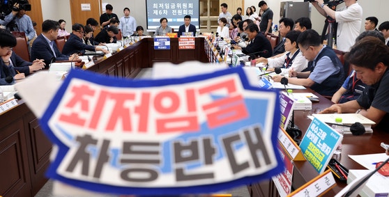 19일 세종시 정부세종청사에서 열린 6차 전원회의에 최저임금 차등반대 머리띠가 등장해 눈길을 끌고 있다. 뉴시스