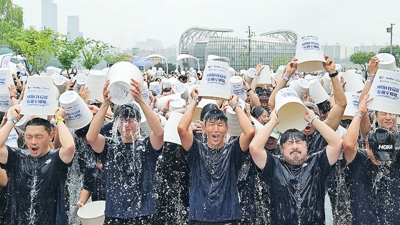 21일 서울반포한강공원 달빛광장 '2025 아이스 버킷 챌린지 런' 행사장에서 배우 양동근씨, 박보검씨, 가수 션, 개그맨 강재준씨, 이영표 축구해설위원(왼쪽부터)과 2000여 명 참가자들이 얼음물을 뒤집어쓰고 있다