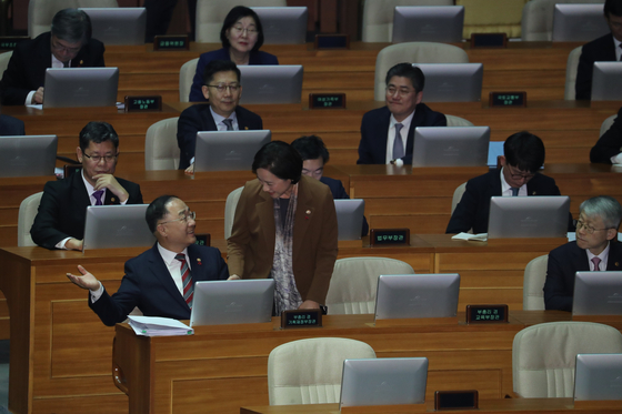 2019년 12월 10일 당시 홍남기 경제부총리 겸 기획재정부 장관이 국회 본회의장에서 자신의 의원석으로 가려고 일어선 유은혜 사회부총리 겸 교육부 장관과 대화하고 있다. 연합뉴스