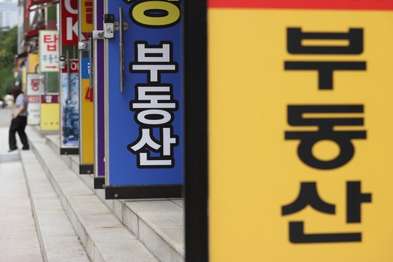 지난달 30일 서울의 한 부동산 중개업소 앞에 시민이 오가고 있다. 업계는 한동안 급매물 위주로만 간간이 거래가 성사되며 전체 거래도 크게 줄 것으로 보고 있다. 연합뉴스