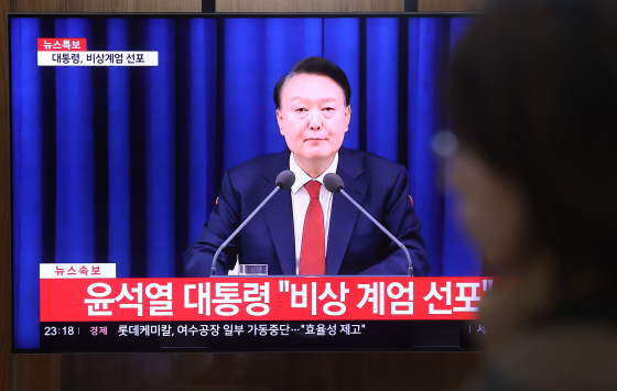 지난해 12월 3일 윤석열 당시 대통령이 비상계엄을 선포한 가운데 서울역에서 관련 뉴스가 나오고 있다. 연합뉴스