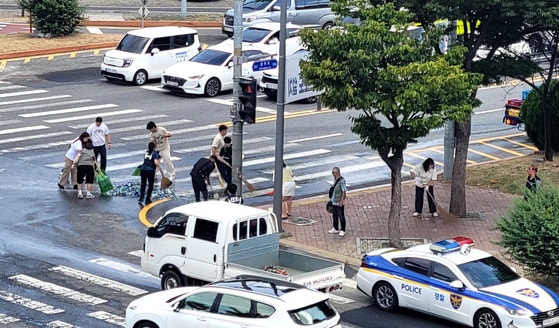 29일 오전 10시 20분께 중구 대사동 충무로 네거리에서 주류 박스를 싣고 달리던 주류 운반 차량에서 맥주병 20상자가 도로위로 쏟아졌다. 대전시체육회 직원들이 쏟아진 맥주병을 치우고 있다. 사진 대전시체육회 =뉴