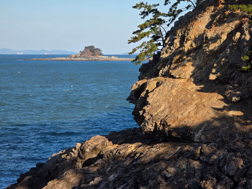 72코스에 있는 독수리바위.이 바위 아래쪽에 와랑창이 있다.멀리 보이는 섬은 여도다.