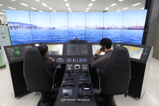 해군의 함정전투체계(CMS)를 개발·공급하는 한화시스템에서 직원들이 콕핏형 통합함교체계(IBS) 장비를 시연하고 있다.[사진 한화시스템]