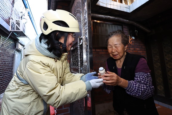 손금주 hy 프레시 매니저가 지난 18일 서울 동대문구 청량리동 인근 주택가에서 독거노인 김옥순씨에게 야구르트를 배달하고 있다.김종호 기자