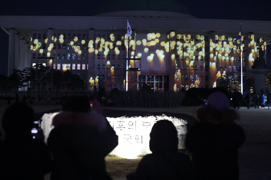 진나 3일 비상계엄 1년을 맞은 3일 오후 서울 영등포구 국회의사당에 계엄 해제 당시 기억을 되새기는 '미디어 파사드'가 펼쳐지고 있다.뉴스1