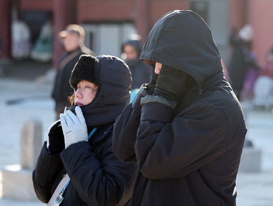 서울과 경기에 한파주의보가 내려진 25일 서울 종로구 경복궁을 찾은 외국인 관광객들이 강추위에 목도리 등 방한용품을 두른채 이동하고 있다.뉴스1