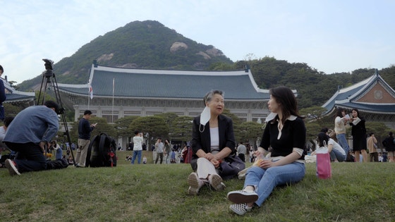 다큐‘청와대 건너 붉은 벽돌집’을 연출한 안소연 감독(오른쪽)이 할머니와 함께 청와대를 찾아,오랜 이웃이지만 범접할 수 없던 곳을 방문한 감회를 나누고 있다.[사진 드림팩트엔터테인먼트]