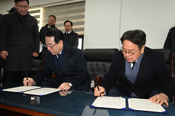 강기정(오른쪽) 광주시장과 김영록 전남도지사가 2일 오전 광주 국립5·18민주묘지에서 시도통합 선언문에 서명하고 있다.뉴시스