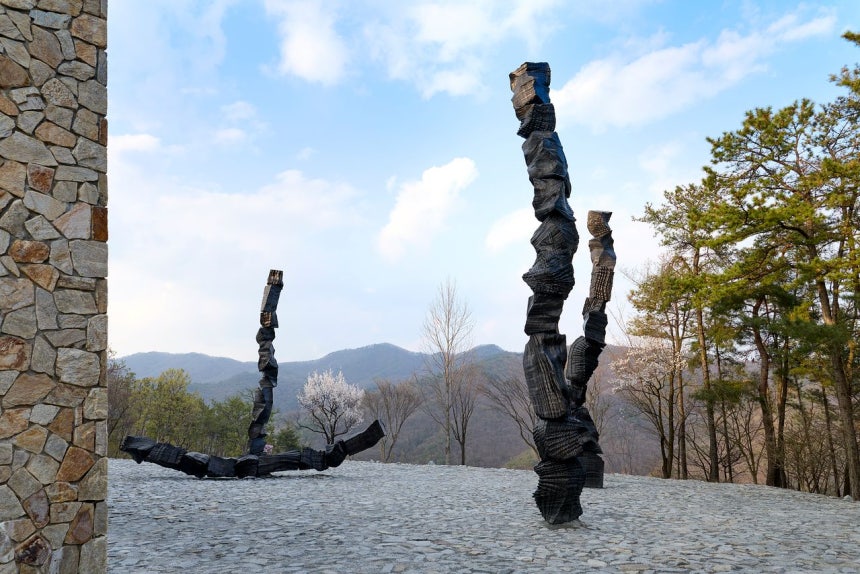 이배는 원주 뮤지엄 산 정원‘무(無)의 공간’에 높이 11m 브론즈 조각‘붓질’6점을 세웠다.미술관 건물 높이만큼 숯을 탑처럼 쌓아올린 모습이다.사진 뮤지엄 산 