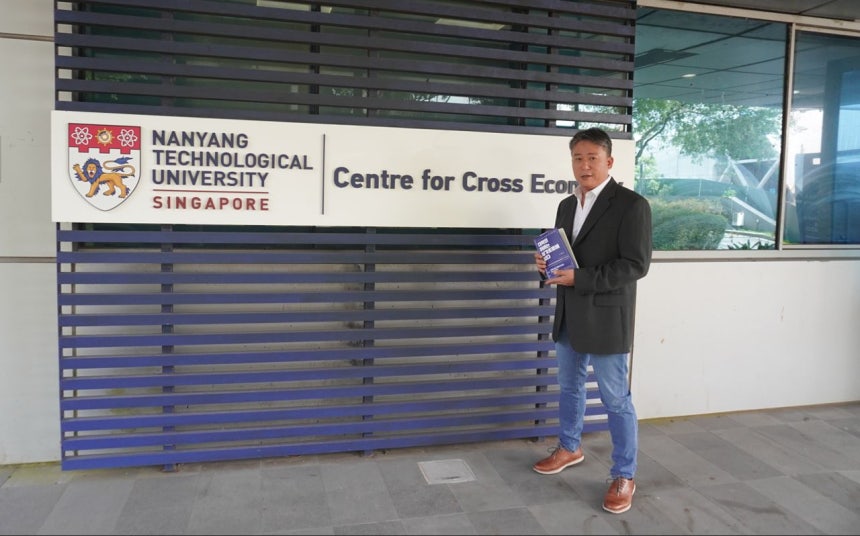 지난 10일 싱가포르 난양공대 변환경제센터 앞에서 조남준 교수가 최근 펴낸 『대학의 미래는 싱가포르에 있다』를 소개하고 있다.사진 NTU