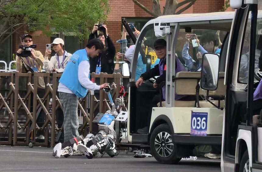 19일 중국 베이징시 이좡에서 개최된 '제2회 휴머노이드 로봇 하프마라톤 대회'에 참가한 한 로봇이 회전로를 돌지 못하고 울타리에 부딪혀 쓰러져있다. 연합뉴스