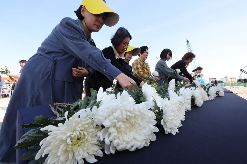 지난달 16일 오후 전남 목포신항에서 세월호 참사 12주기 목포기억식에 참여한 추모객들이 헌화하고 있다.사진 뉴시스