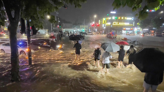 2022년 8월 8일 밤 서울 관악구 도림천이 범람, 시민들이 아슬아슬하게 물살을 헤쳐 길을 건너고 있는 모습. 뉴스1