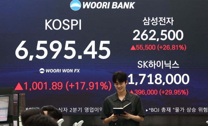 코스피가 폭등하며 역대 최대 상승세를 보인 지난달 31일 오후 서울 중구 우리은행 본점 딜링룸 전광판에 종가가 나오고 있다.이날 코스피는 전날보다 1001.89포인트(17.91%) 오른 6595.45을 기록했다.
